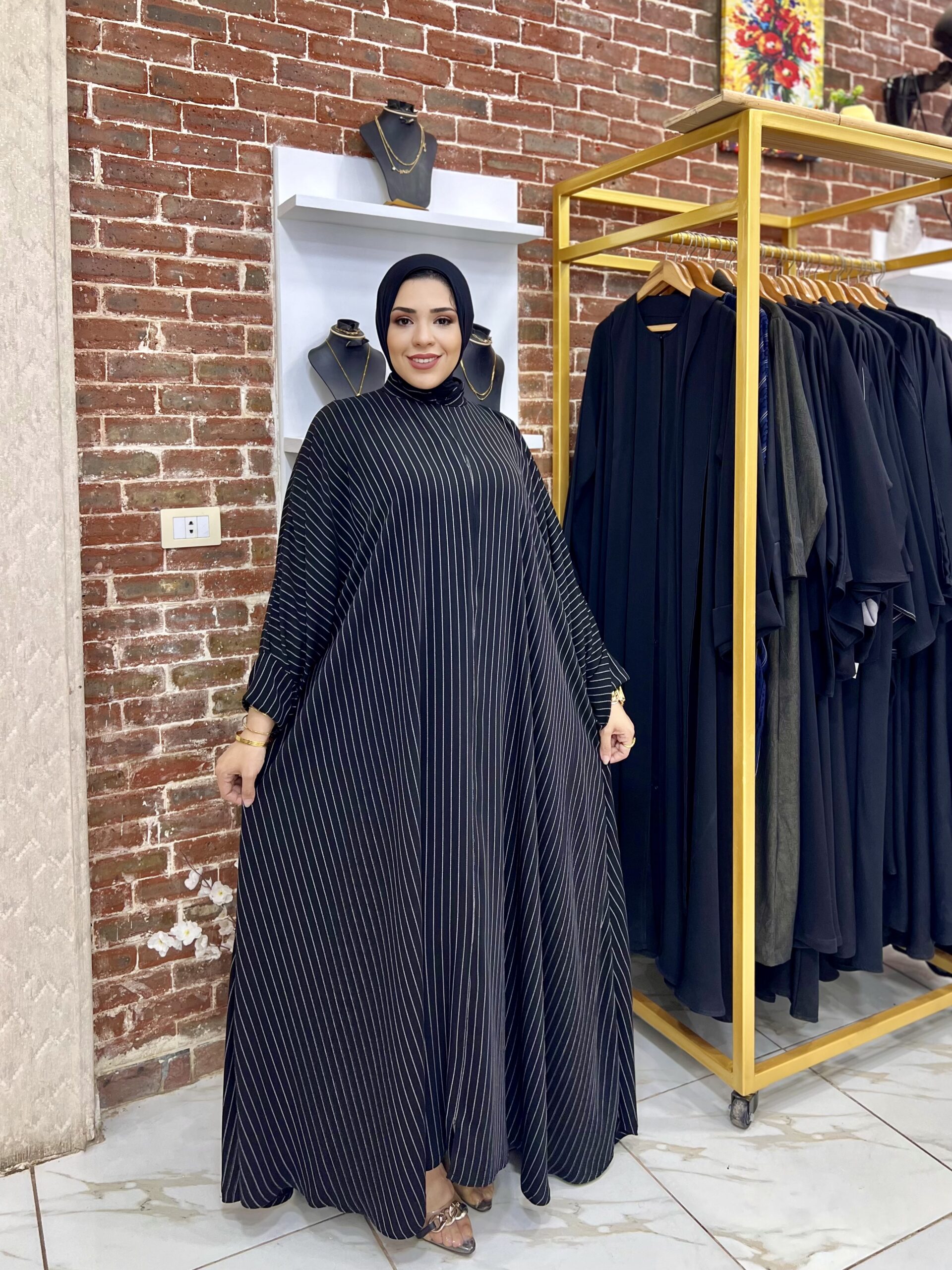 Woman in striped black abaya dress.