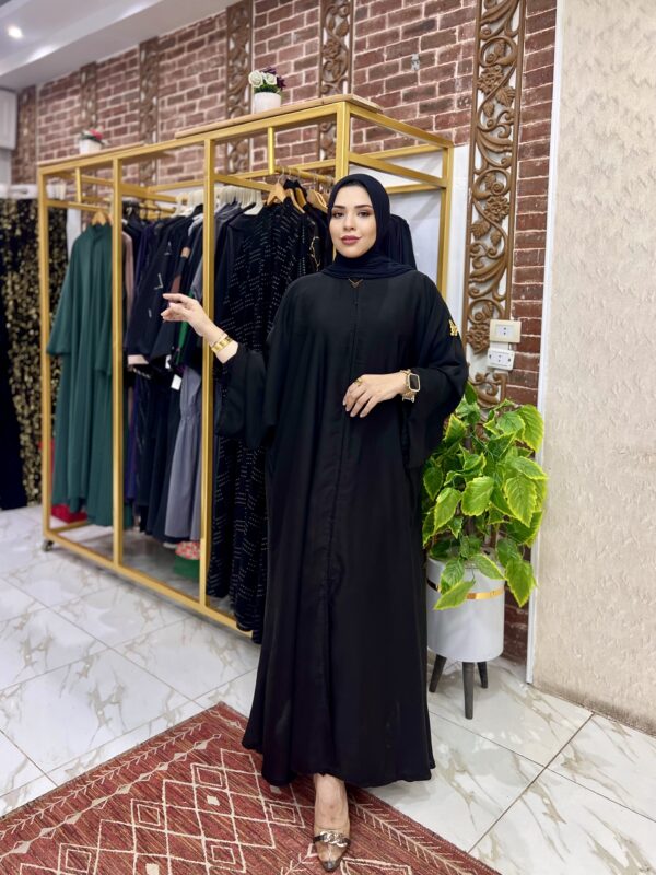 Woman in black dress, boutique setting.